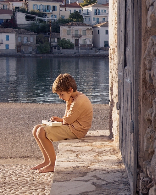Sat down child with water in background